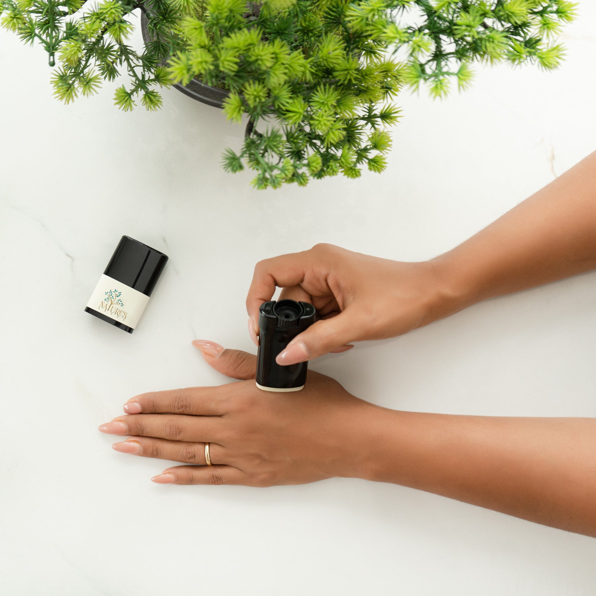 Applying Bonabalm natural hand balm stick to the back of a hand — mess-free glide-on moisturizer by Nature's Grace